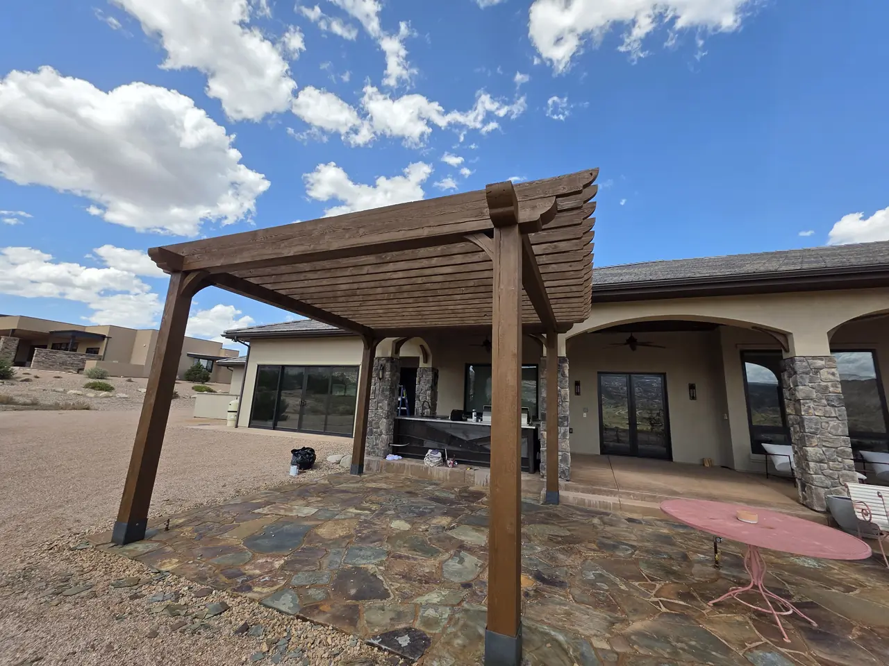 Stained cedar pergola over a flagstone patio