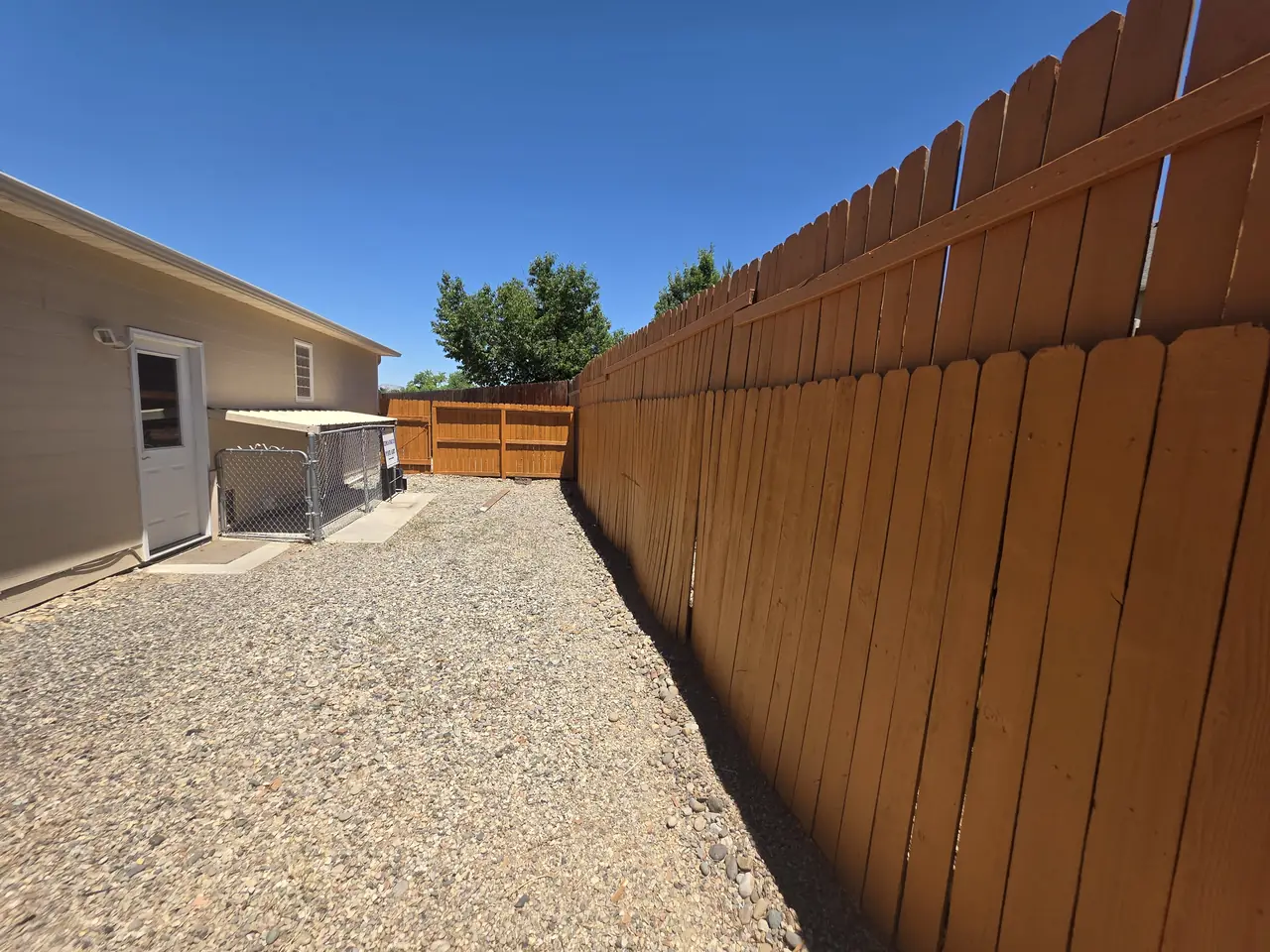 Long run of freshly stained privacy fence along a side yard